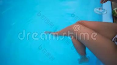 女腿在游泳池里飞溅。 在阳光明媚的<strong>夏日</strong>里，<strong>小</strong>女孩`双腿在<strong>清</strong>澈的池水里呀